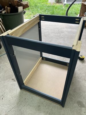 A DIY server rack made out of scrap wood on the concrete floor of a garage