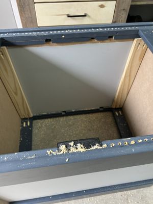 A closeup of the server rack side, showing mounting holes being drilled